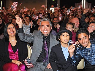 Cesar Millan in a grey formal dress with his wife in a black and pink dress along with their sons on formal attires.